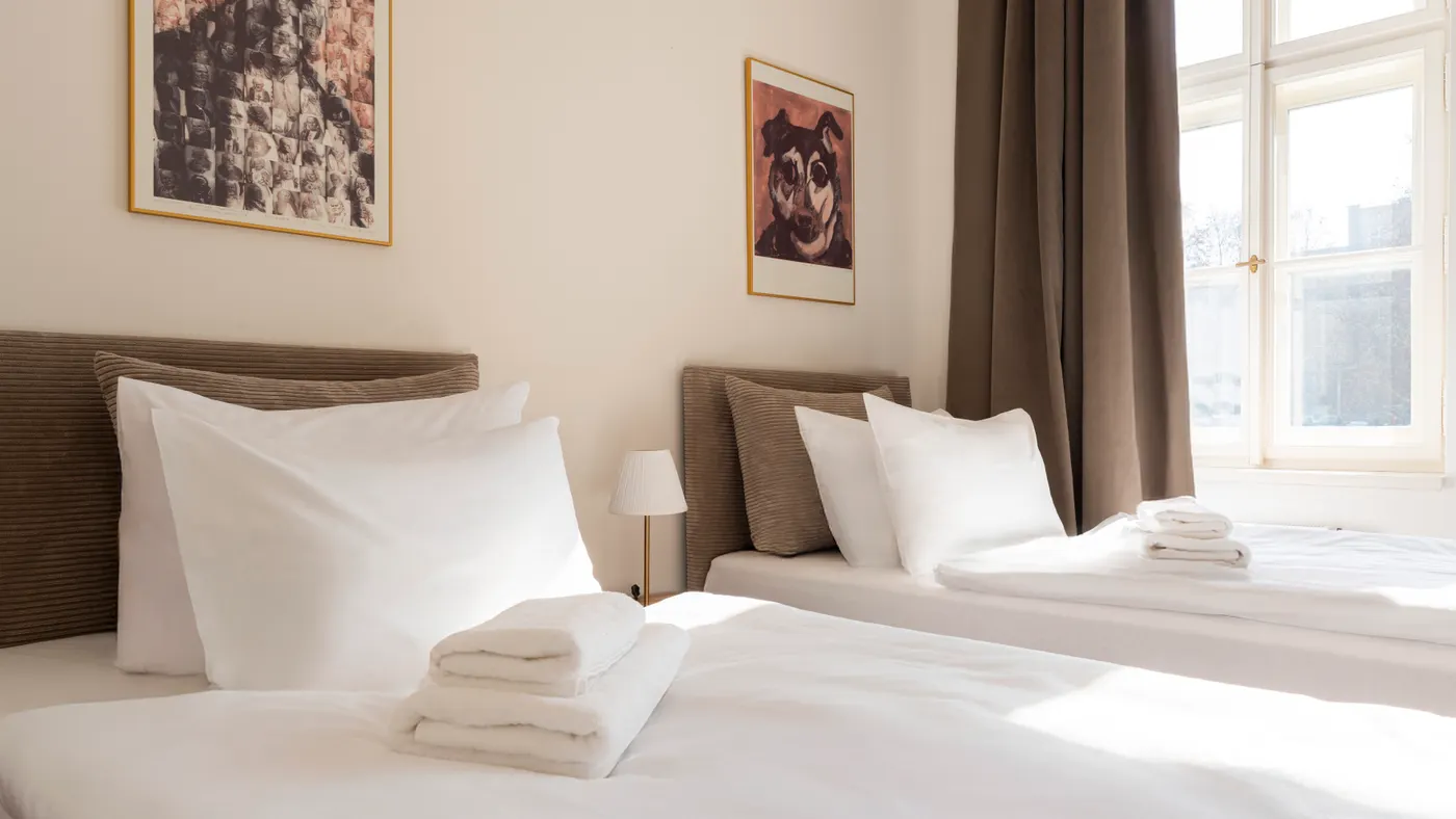 Przygotowany apartament premium w ciepłym świetle: zasłane łóżko i czyste wnętrze